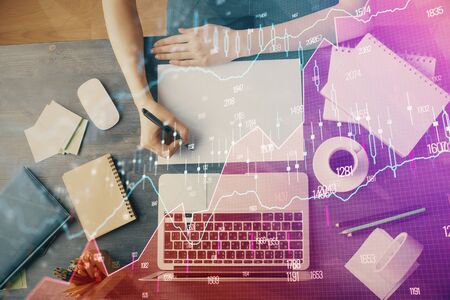 Financial graph displayed on woman's hand taking notes background. Concept of research. Multi exposureの写真素材