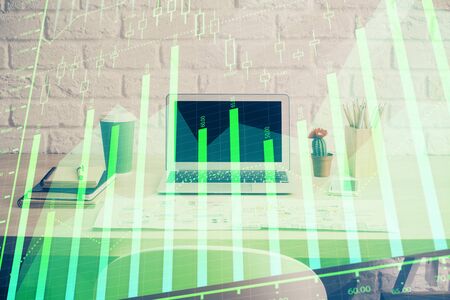 Stock market chart hologram drawn on personal computer background. Double exposure. Concept of investment.の写真素材