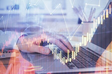 Double exposure of stock market graph with man working on laptop on background. Concept of financial...