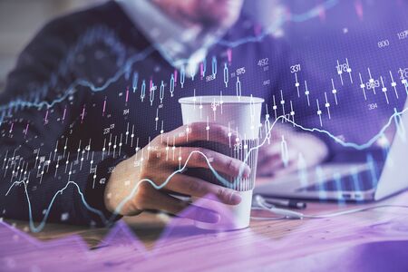 Forex graph with businessman working on computer in office on background. Concept of hardworking....
