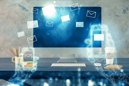 Desktop computer background in office and flying envelops hologram drawing. Multi exposure. Electronic mail concept.の写真素材