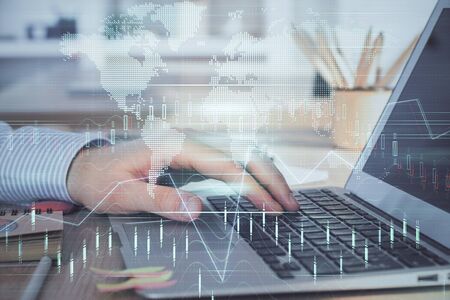 Double exposure of stock market graph with man working on laptop on background. Concept of financial analysis.の写真素材