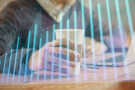 Forex graph with businessman working on computer in office on background. Concept of hardworking. Closeup. Multi exposure.の写真素材