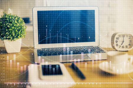 Financial chart drawing and table with computer on background. Multi exposure. Concept of international markets.の写真素材