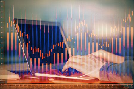 Double exposure of stock market graph with man working on laptop on background. Concept of financial...