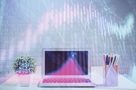 Financial chart drawing and table with computer on background. Multi exposure. Concept of international markets.の写真素材