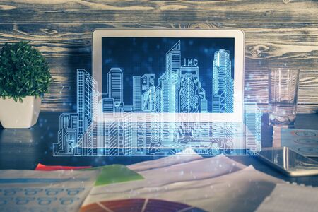 Desktop computer background in office and big town buildings hologram drawing. Double exposure. Smart city concept.の写真素材