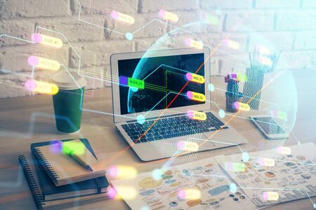 Double exposure of desktop with computer and world map hologram. International data network concept.の写真素材