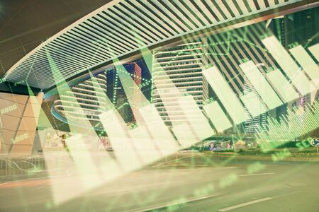 Forex chart on cityscape with tall buildings background multi exposure. Financial research concept.の写真素材