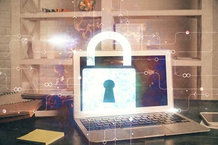 Double exposure of desktop with computer and lock icon hologram. Concept of data safety.