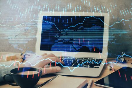 Forex graph with businessman working on computer in office on background. Concept of hardworking. Double exposure.の写真素材