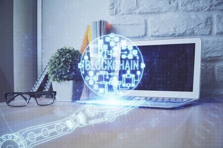 Double exposure of blockchain theme hologram and table with computer background. Concept of bitcoin crypto currency.の写真素材