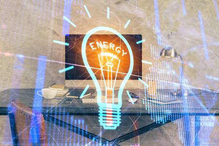 Computer on desktop in office with bulb icon hologram. Multi exposure. Concept of idea.の写真素材
