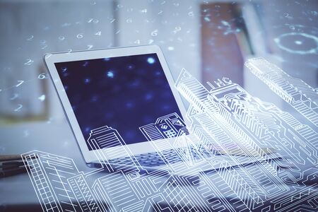 Desktop computer background in office and big town buildings hologram drawing. Double exposure....