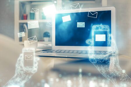 Desktop computer background in office and flying envelops hologram drawing. Multi exposure. Electronic mail concept.の写真素材