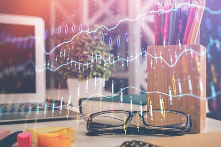 Financial chart hologram with glasses on the table background. Concept of business. Double exposure.の写真素材