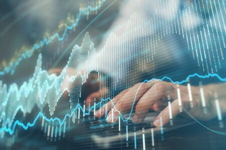 Forex graph with businessman working on computer in office on background. Concept of hardworking....