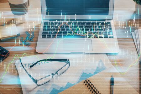 Double exposure of graph and financial info and work space with computer background. Concept of international online trading.の写真素材