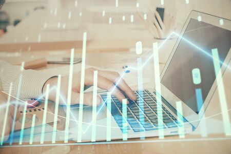 Double exposure of stock market graph with man working on laptop on background. Concept of financial analysis.の写真素材