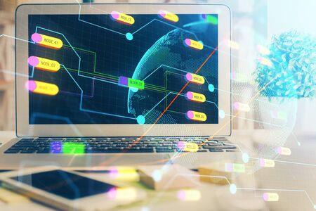 Double exposure of desktop with computer and world map hologram. International data network concept.