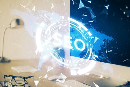 Double exposure of table with computer and seo drawing hologram. Search optimization concept.の写真素材