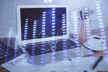 Forex market graph hologram and personal computer on background. Multi exposure. Concept of investment.の写真素材
