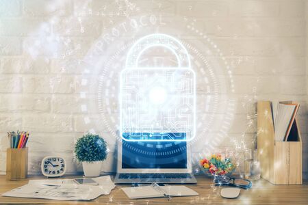 Double exposure of desktop with computer and lock icon hologram. Concept of data safety.の写真素材