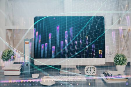 Forex graph hologram on table with computer background. Double exposure. Concept of financial markets.の写真素材