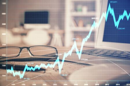 Financial chart hologram with glasses on the table background. Concept of business. Double exposure.