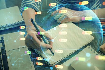 Double exposure of hands making notes with digital coding icons. Computer learning concept.