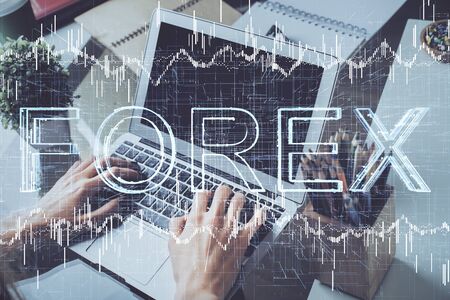 Double exposure of stock graph with businessman typing on computer in office on background. Concept of hard work.の写真素材