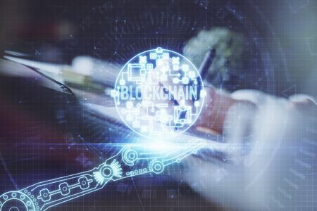 Cryptocurrency hologram, bitcoin, ico theme over hands taking notes background. Concept of...
