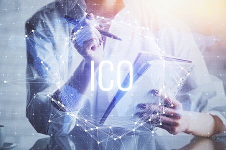 Cryptocurrency hologram, bitcoin, ico theme over hands taking notes background. Concept of blockchain. Multi exposureの写真素材