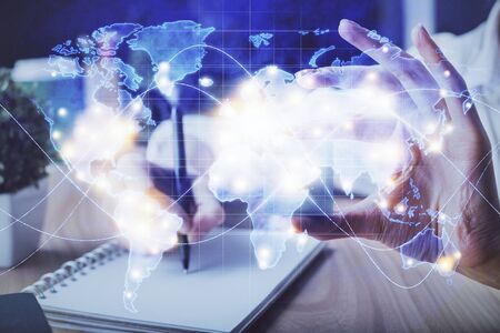 International business hologram over woman's hands taking notes background. Concept of success. Double exposureの写真素材