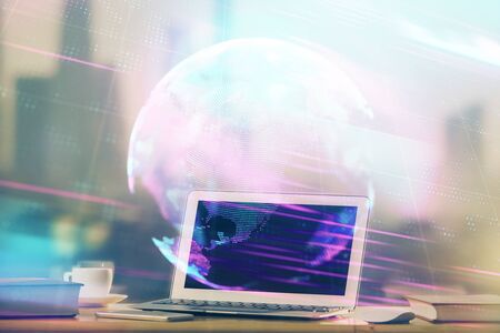 Computer on desktop in office with technology theme hologram. Multi exposure. Tech concept.の写真素材