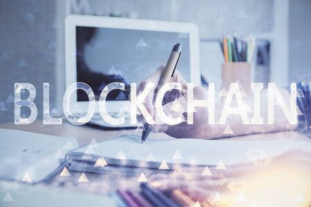 Cryptocurrency hologram, bitcoin, ico theme over hands taking notes background. Concept of blockchain. Multi exposureの写真素材