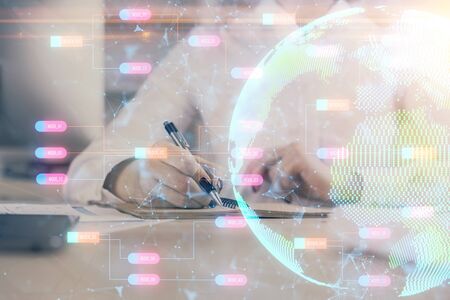 Double exposure of hands making notes with world map hologram and data theme icons. Concept of international network data.の写真素材