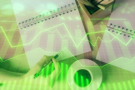 Multi exposure of womans hands making notes with forex graph hologram.の写真素材