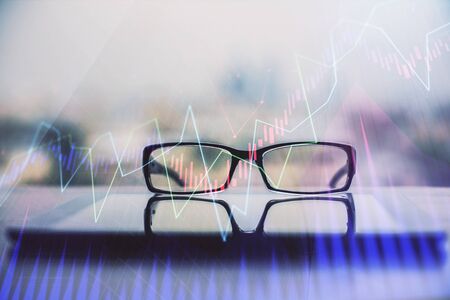 Financial graph hologram with glasses on the table background. Concept of business. Double exposure.の写真素材