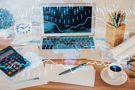 Financial graph colorful drawing and table with computer on background. Double exposure. Concept of international markets.の写真素材