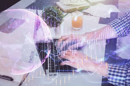 Double exposure of graph with man typing on computer in office on background. Concept of hard work.の写真素材
