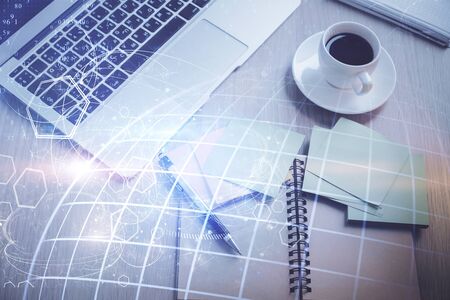 Double exposure of map hologram drawing over study table background with computer. Concept of international network. Top view.の写真素材