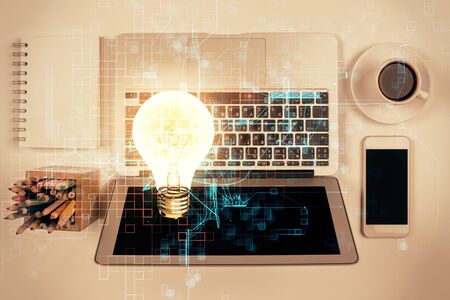 Bulb drawing over computer on the desktop background. Top view. Double exposure. Idea concept.の写真素材