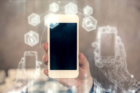 Double exposure of mans hands holding and using a digital device and tech theme hologram drawing. Technology concept.の写真素材