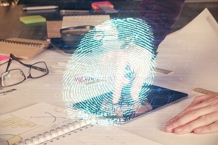 Double exposure of man's hands holding and using a digital device and fingerprint hologram drawing. Security concept.の写真素材