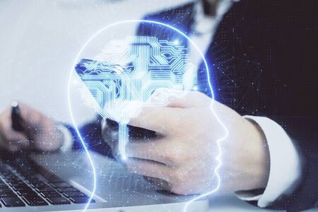 Double exposure of man's hand holding and using a digital device and brain hologram drawing. Data...