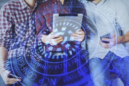 Double exposure of data theme hologram drawing and man and woman working together holding and using a mobile device.の写真素材