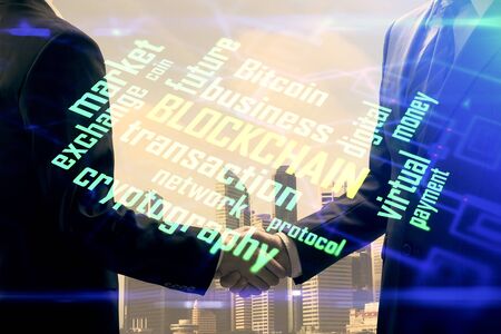 Double exposure of blockchain hologram and handshake of two men. Crypto business concept.の写真素材
