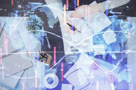 International business hologram over womans hands taking notes background. Concept of success. Double exposureの写真素材