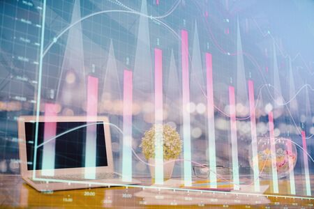 Forex graph hologram on table with computer background. Double exposure. Concept of financial markets.の写真素材